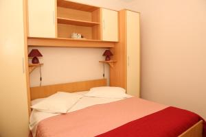 ein kleines Schlafzimmer mit einem Bett und Regalen in der Unterkunft Seaside holiday house Prigradica, Korcula - 18002 in Blato