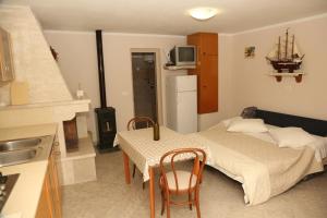 Zimmer mit einem Bett und einem Tisch sowie einer Küche in der Unterkunft Seaside holiday house Prigradica, Korcula - 18002 in Blato