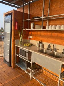 een keuken met een wastafel en een magnetron bij Atlit Rooftop Glamping in Atlit