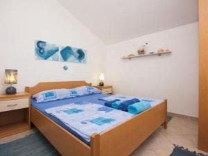 a bedroom with a bed with blue pillows on it at Family friendly seaside apartments Krapanj, Sibenik - 18004 in Šibenik