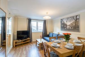 ein Wohnzimmer mit einem Tisch und einem blauen Sofa in der Unterkunft Stay Saint Paul's in London