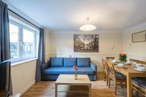 Una sala de estar con un sofá azul y una mesa. en Stay Saint Paul's, en Londres