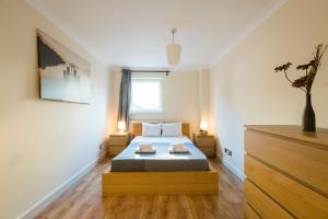 a bedroom with a bed with two lamps and a dresser at Stay Saint Paul's in London