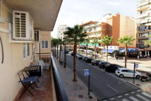- une vue sur une rue bordée de palmiers et de bâtiments dans l'établissement Fuengirola, sol y playa., à Fuengirola
