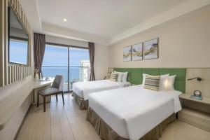 ニャチャンにあるAtlantic Nha Trang Hotelのベッド2台 ホテルルーム オーシャンビュー