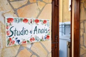 a sign on a wall with flowers on it at studio ANAIS in Galaxidhion