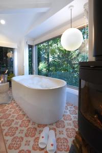 a large white bath tub in a room with a fireplace at Lovestone Cottages Montville in Montville