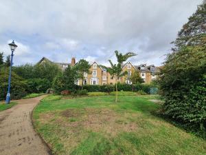 a large house with a lawn in front of it at Spacious 1 Bed Flat in Central Slough in Slough