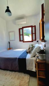 林都斯的住宿－The Olive Tree Villa Lindos，一间卧室设有一张大床和一个窗户。