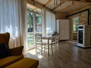 una cucina e una sala da pranzo con tavolo e sedie di Domek Leśny bungalow a Rudawica