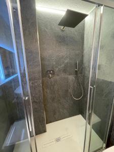 La salle de bains est pourvue d'une douche avec une porte en verre. dans l'établissement Baita del Cervino CIR n 0016, à Breuil-Cervinia