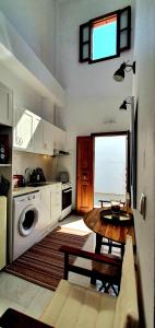 a kitchen with a table and a kitchen with a window at The Olive Tree Villa Lindos in Lindos