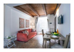 a living room with a red couch and a table at Il Borgo di Tresana Casa Marina in Tresana