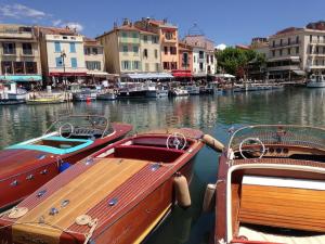 two boats are docked in a harbor with buildings at Au son des Cigales in Cassis