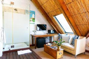 sala de estar con sofá y escritorio en Adventure Pad's by The Farmhouse Hotel, en Langebaan