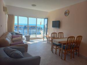 a living room with a couch and a table and chairs at Vega Village Ap A8 in Sveti Vlas