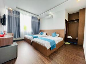 a hotel room with two beds and a television at Thanh Binh Hotel Con Dao in Con Dao