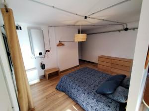 um quarto com uma cama azul e uma janela em Loft Mieres em Mieres