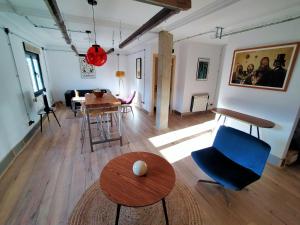 uma sala de estar com uma cadeira azul e uma mesa em Loft Mieres em Mieres