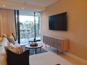 a living room with a couch and a flat screen tv at Juliette 208 in Cape Town