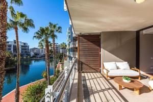 balcón con sofá, mesa y agua en Juliette 208, en Ciudad del Cabo