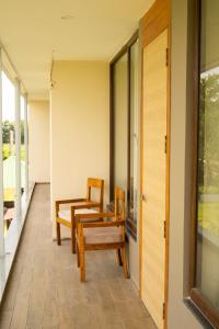 a room with chairs and a table on a porch at Chang's Garden & Resort in Golāghāt