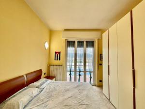 a bedroom with a bed and a sliding glass door at Casa Conchiglia in Vado Ligure