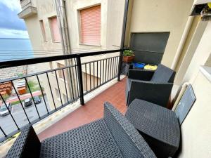 a balcony with chairs and tables and a view of the ocean at Casa Conchiglia in Vado Ligure
