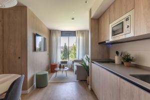 a kitchen with a counter and a living room at Apartamentos Líbere Pamplona Yamaguchi in Pamplona