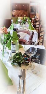 a table with a white table cloth with glasses and flowers at Café & Gästehaus Reichel in Bärenstein