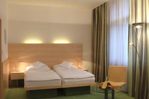 a bedroom with a bed and a table and a chair at Hotel DAP in Prague