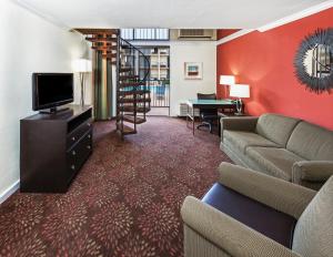 een woonkamer met een bank en een televisie bij Holiday Inn Tyler - Conference Center, an IHG Hotel in Tyler