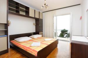 a bedroom with a large bed and a large window at Rooms with a parking space Brela, Makarska - 17281 in Brela