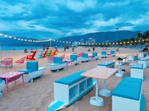 a beach with chairs and tables and people on the beach at Thiên Hải 2 Hotel in Quy Nhon