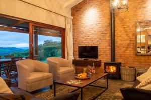 a living room with a couch and a fireplace at Hilton Bush Lodge & Function Venue in Hilton