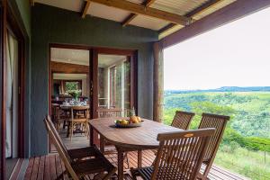 a porch with a wooden table and chairs on a deck at Hilton Bush Lodge & Function Venue in Hilton