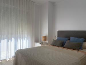 Un dormitorio con una cama con almohadas azules y una ventana en AGRADABLE CASA EN SAN JOSE, en San José