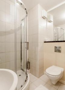 uma casa de banho com um WC, um chuveiro e um lavatório. em Parnell Apartments em Dublin