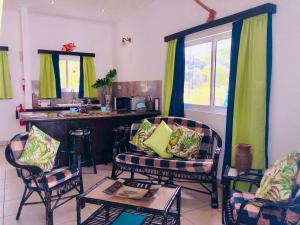 a living room with two chairs and a table at Cap Jean Marie Beach Villas in Anse Kerlan