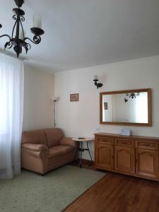 a living room with a couch and a mirror at Studio flat in Chişinău