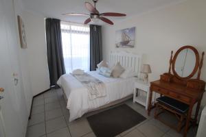a bedroom with a bed with a ceiling fan and a mirror at Mont Blanc 17 in Margate
