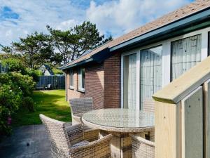 a patio with a glass table and chairs at Op 't Landtweg 35 in Callantsoog
