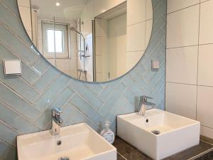 a bathroom with two sinks and a large mirror at Op 't Landtweg 35 in Callantsoog +8 photos