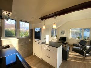 a kitchen and living room with a sink and a counter at Op 't Landtweg 35 in Callantsoog