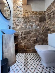 a bathroom with a stone wall and a sink and a tub at Casas rurales Villa la Roza in La Utrera