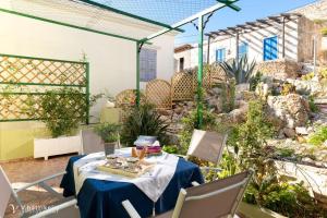 eine Terrasse mit einem Tisch und Stühlen im Garten in der Unterkunft Villa Lola in Chalki