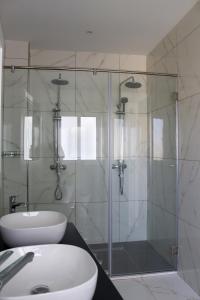 a bathroom with a glass shower and a sink at 100 Boutique Living in Rabat