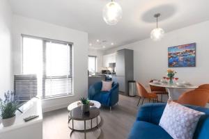 uma sala de estar com um sofá azul e uma mesa em Elliot Oliver - Cosy 2 Bedroom Town Centre Apartment em Cheltenham