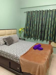 a bedroom with a bed with purple gloves on it at Budget Friendly Transient in Valley Mansions hosted by Aliyah in Cainta