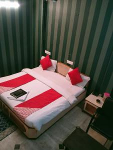 a bedroom with a large bed with red pillows at HOTEL SHREE VILLA in Harsola